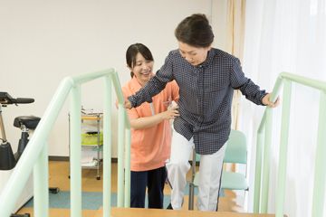 階段を登るのを手助けするスタッフ