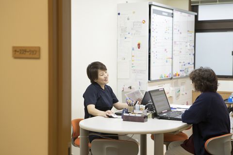 パソコン見ながら話し合う看護部女性スタッフ2名