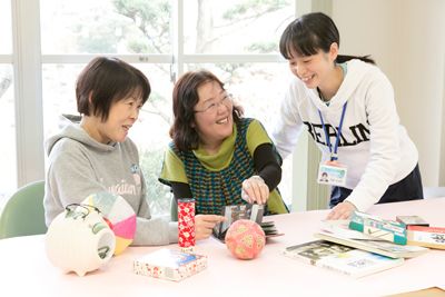 写真を見る二人の高齢者とスタッフ