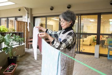 生活リハビリテーションとして洗濯物を干す女性