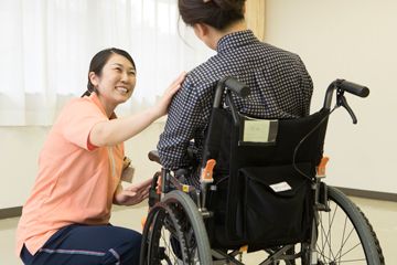 車椅子の人に話しかけるスタッフ