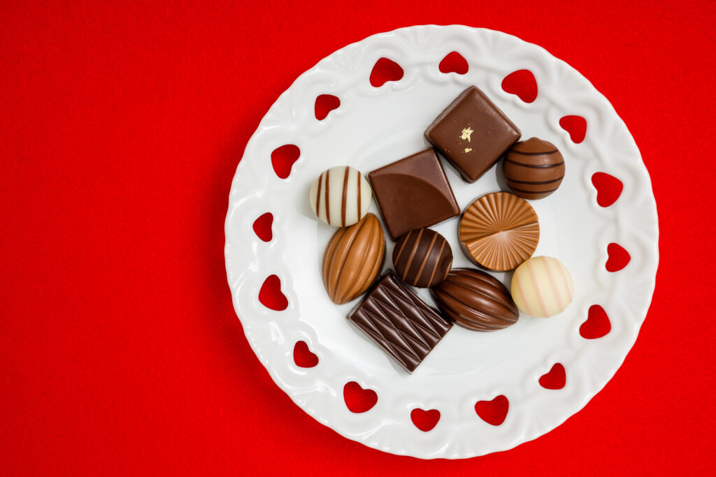 赤い布の上に白いお皿、その上にチョコレートが置かれた写真